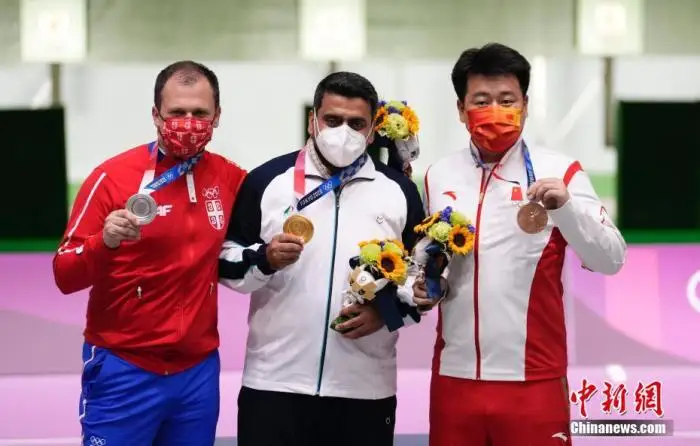 7月24日，东京奥运会男子10米气手枪比赛举行，中国选手庞伟(右一)获得铜牌。伊朗选手福鲁吉获得金牌，塞尔维亚老将米科奇获得银牌。